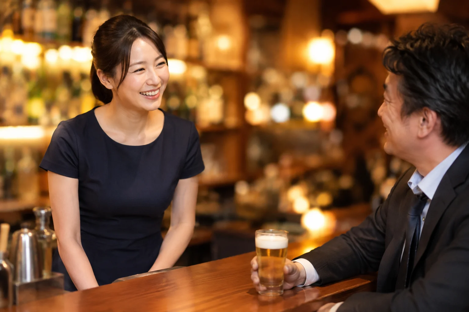 新橋の気取らないお店で会社員のお客様と会話を楽しむ女性